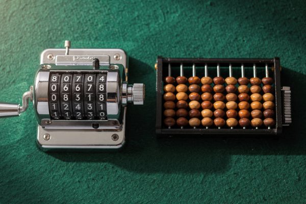 Pool score counters including mechanical hand counter and abacus bead counter on green felt