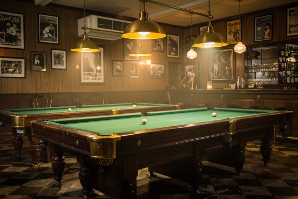 Vintage pool hall interior showing classic billiard tables and historical atmosphere from mid-20th century