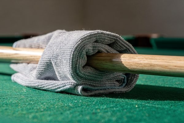 Professional microfiber towel cleaning pool cue shaft for equipment maintenance